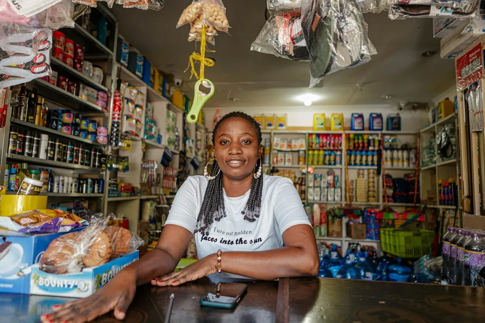 Une commerçante derrière le comptoir de sa boutique d’alimentation